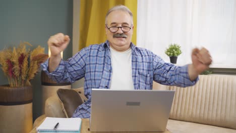Man-looking-at-laptop-is-happy-and-dancing.